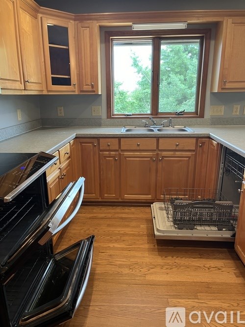 A kitchen with wooden cabinets and a black oven.