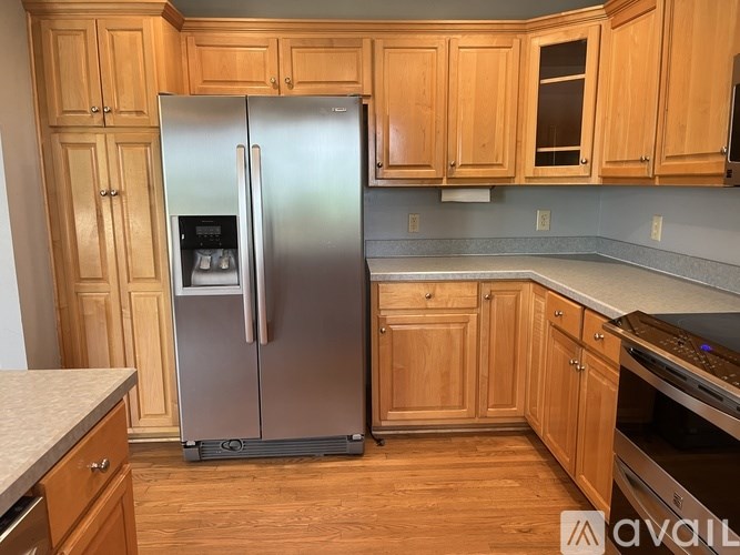 A kitchen with a refrigerator, cabinets, and a countertop.