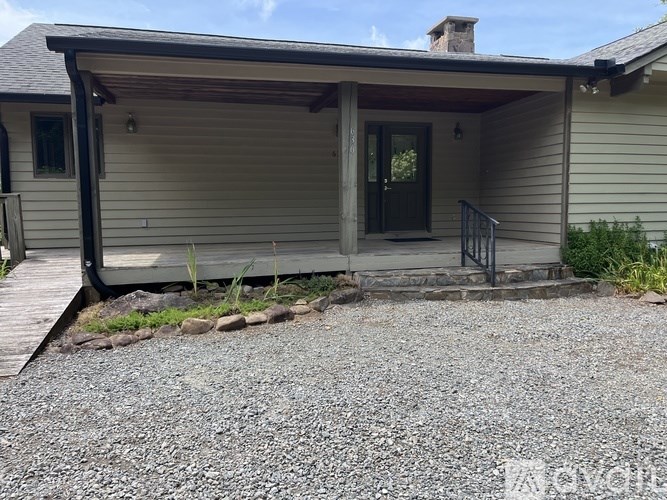 A house with a gravel driveway in front.