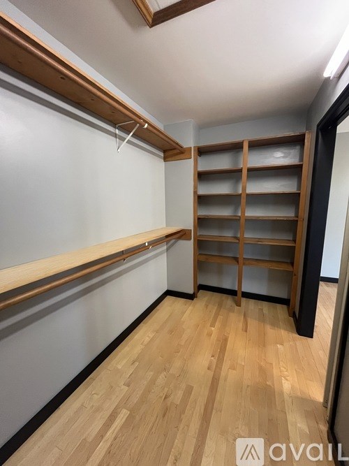 A room with wooden floors and shelving units.