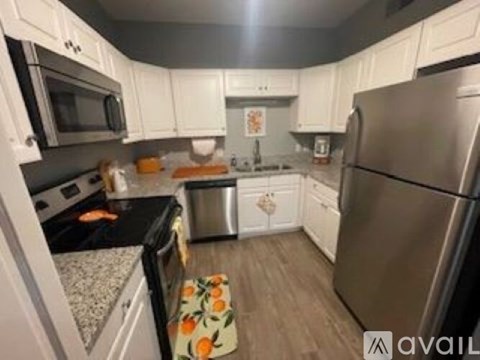 A kitchen with white cabinets and a black stove top.