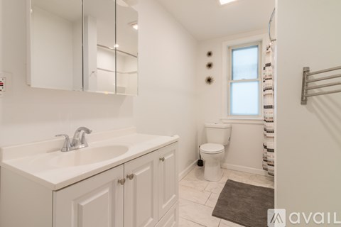 A bathroom with a toilet, sink, and mirror.