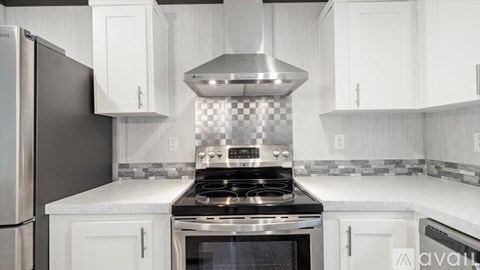 A modern kitchen with a stove top oven and a refrigerator.