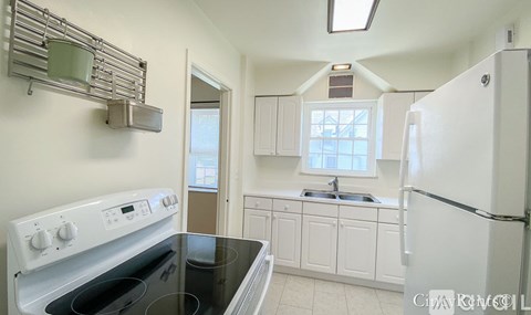 A kitchen with a stove top oven and a refrigerator.
