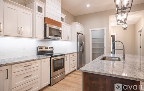 A kitchen with white cabinets and a granite countertop.