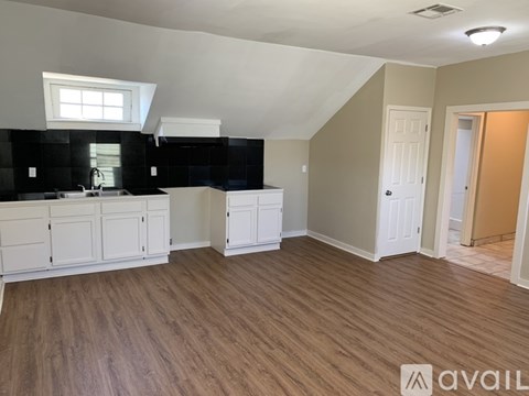 A kitchen with white cabinets and a black countertop.