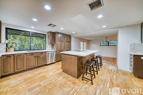 A kitchen with wooden cabinets and a bar area.
