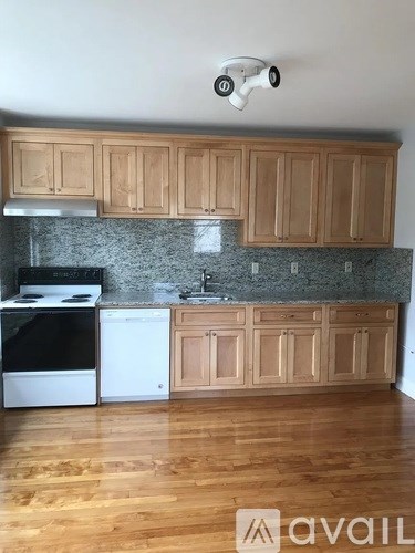A kitchen with wooden cabinets and a black stove top oven.
