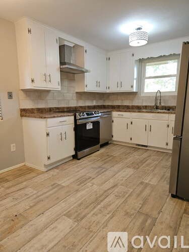 A kitchen with a black stove top oven and white cabinets.