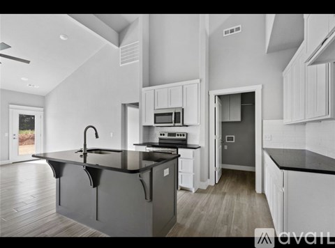 A modern kitchen with a black countertop and white cabinets.