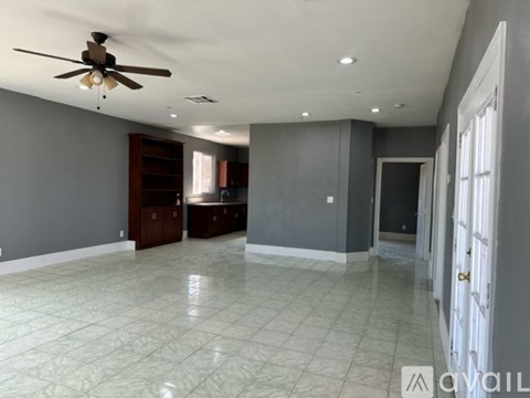 A spacious room with a ceiling fan and tiled flooring.