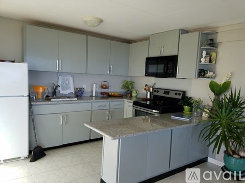 A kitchen with a white fridge, grey cabinets and a black stove.