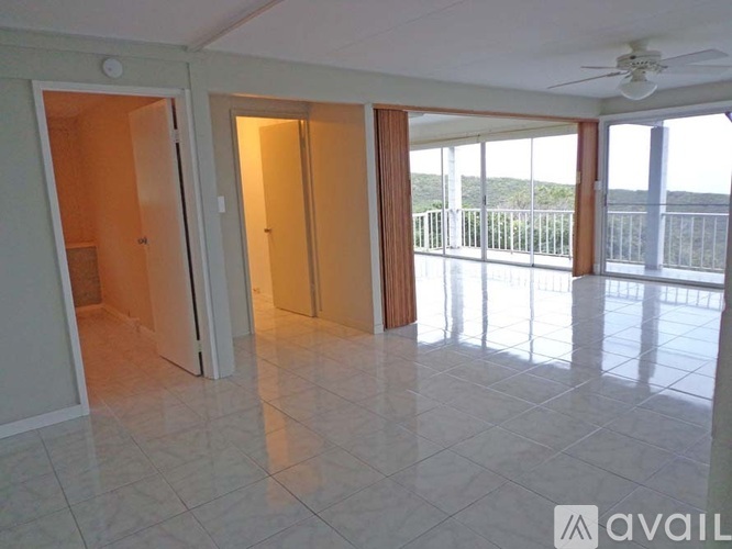 A spacious room with a balcony overlooking the ocean.