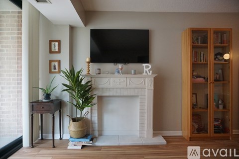 A living room with a fireplace and a television mounted on the wall.