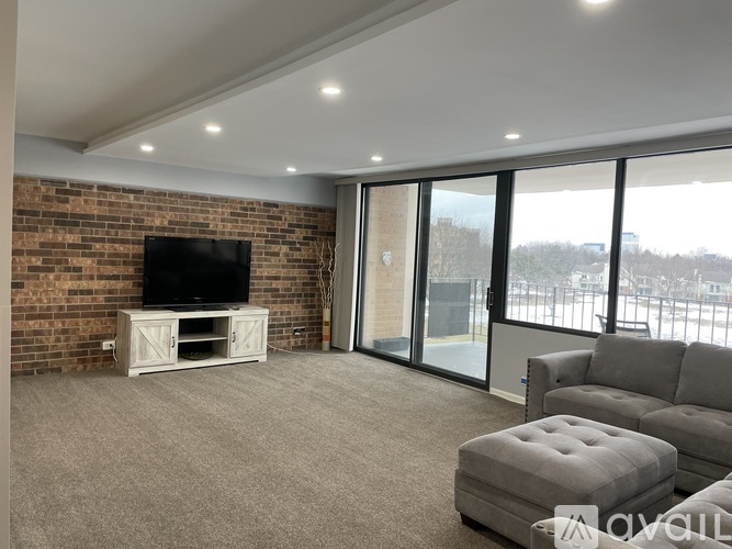 A living room with a flat screen TV and grey sofa.