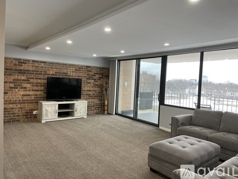A living room with a flat screen TV and grey sofa.