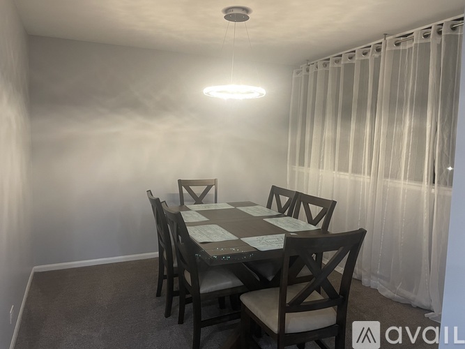 A dining room with a table and chairs.