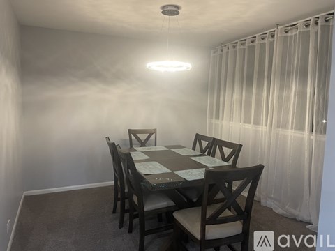 A dining room with a table and chairs.