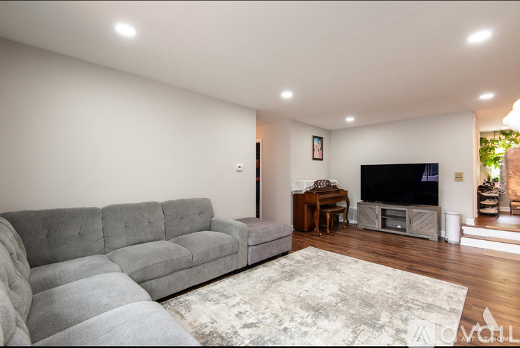 A living room with a grey sofa and a television.