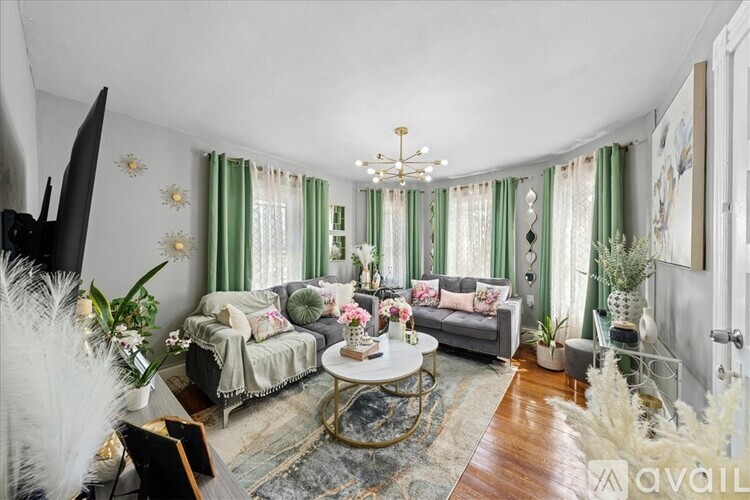 A living room with a grey couch, a coffee table, and a chandelier.