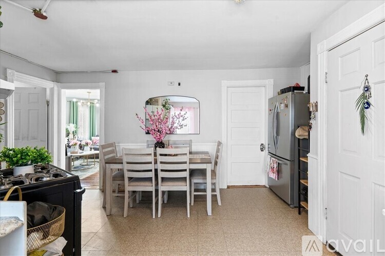 A kitchen with white cabinets and a wooden floor.