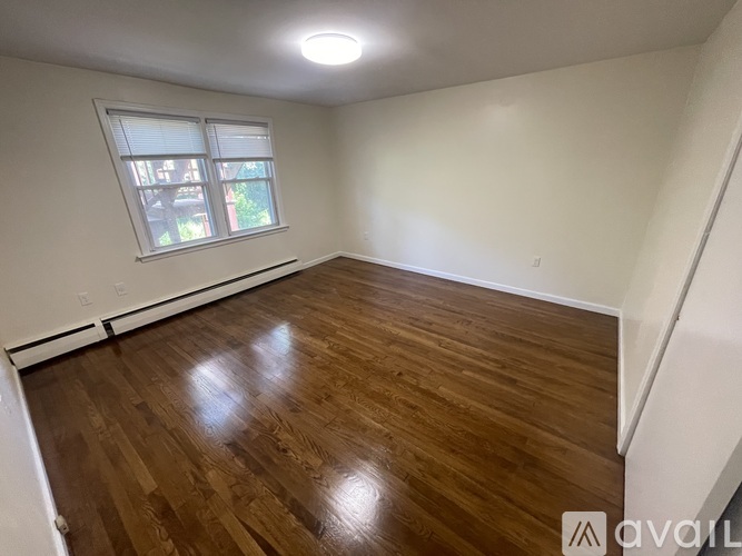 A room with wooden flooring and a window.