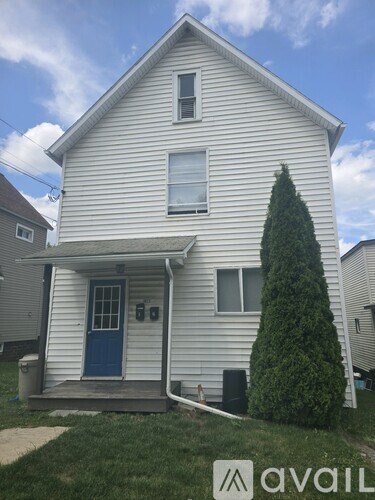 A two-story house with a blue door and a small porch.