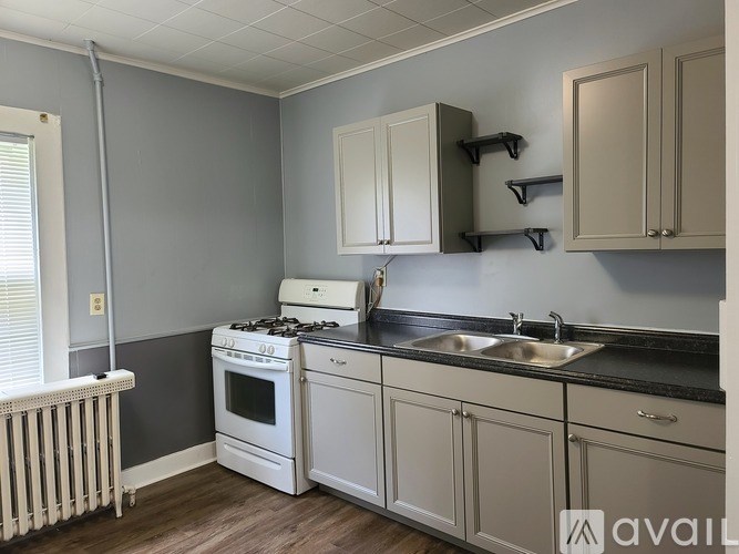 A kitchen with a white stove and cabinets.