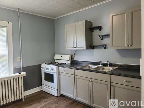 A kitchen with a white stove and cabinets.