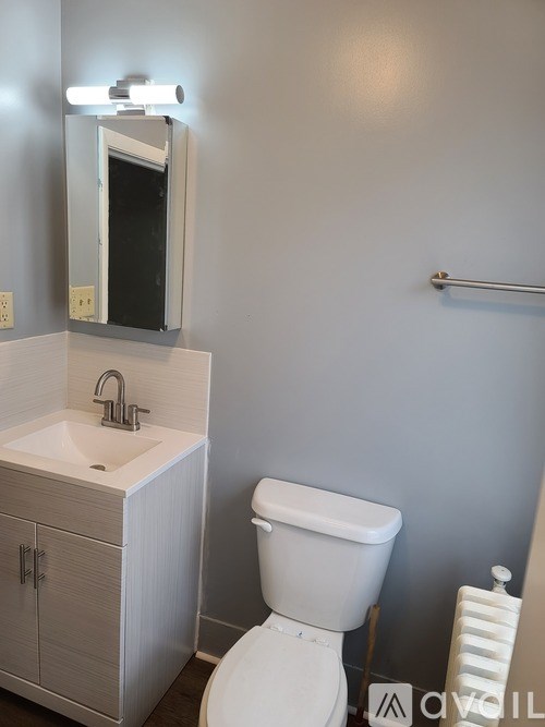 A white toilet sits next to a sink in a bathroom.