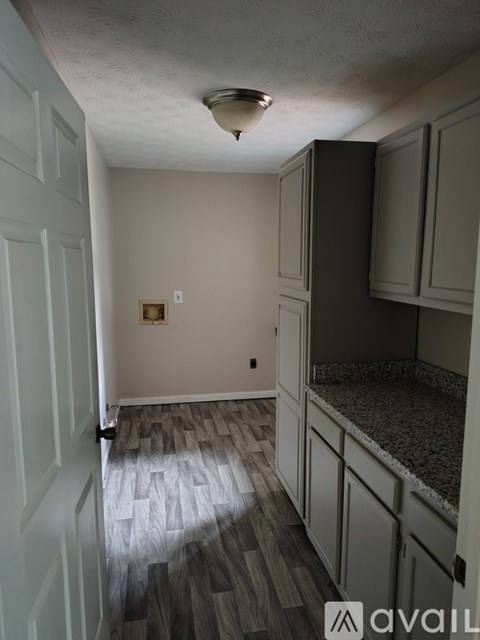 A kitchen with a white door and cabinets.