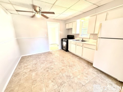 A kitchen with a refrigerator, oven, and microwave.