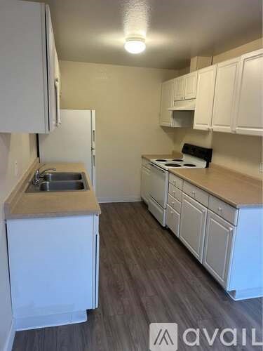 A kitchen with white cabinets and a wooden countertop.
