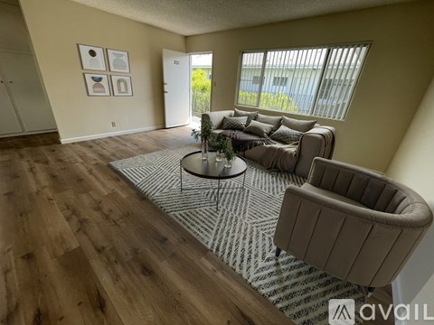 A living room with a couch, chair, and a table with a plant on it.