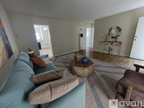 A living room with a blue couch and a wooden coffee table.