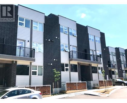 A modern apartment building with balconies and a car parked in front.