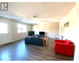 A living room with a couch, a chair, and a television.