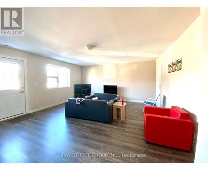 A living room with a couch, a chair, and a television.