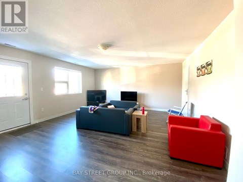 A living room with a couch, a chair, and a television.