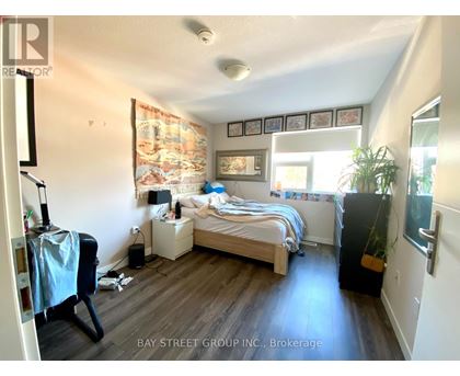 A bedroom with a bed, nightstand, and chair.