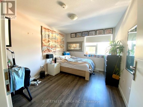 A bedroom with a bed, nightstand, and chair.