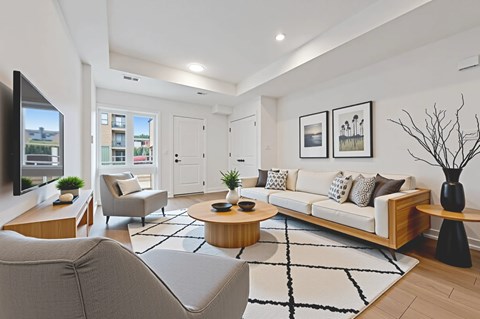 A modern living room with a white sofa, grey armchair, and a coffee table.