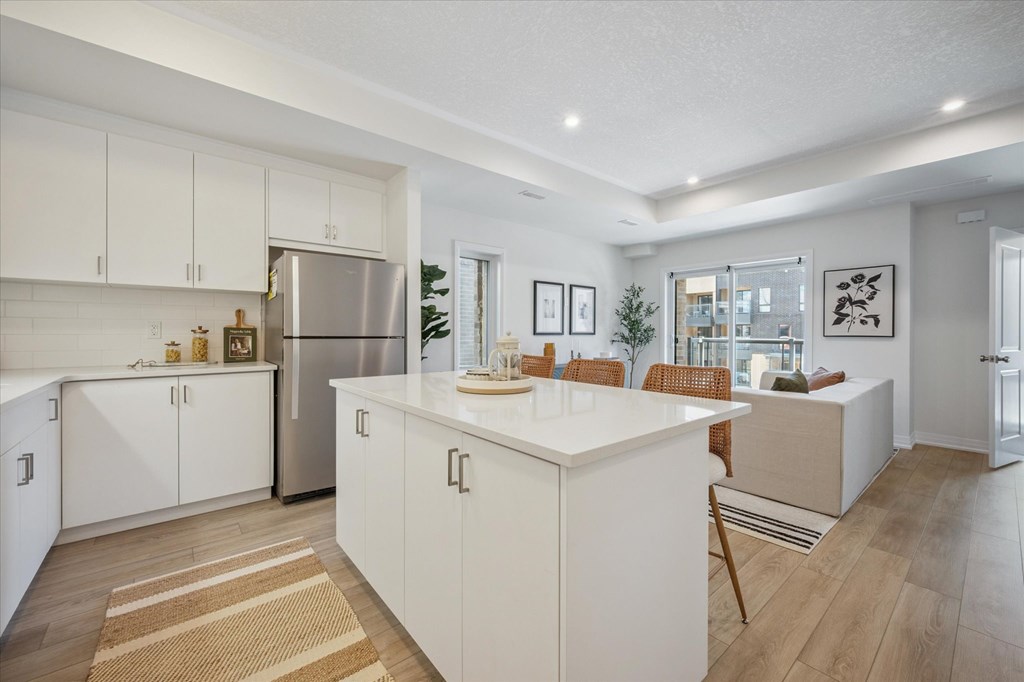 A kitchen with white cabinets and a wooden floor.