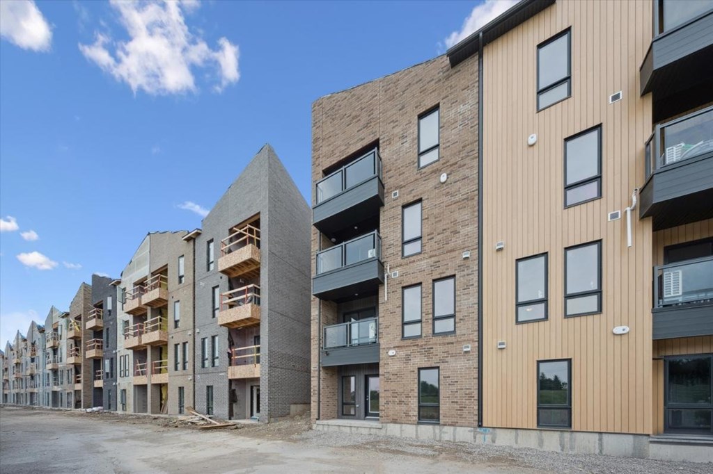 A row of modern apartment buildings with balconies and windows.