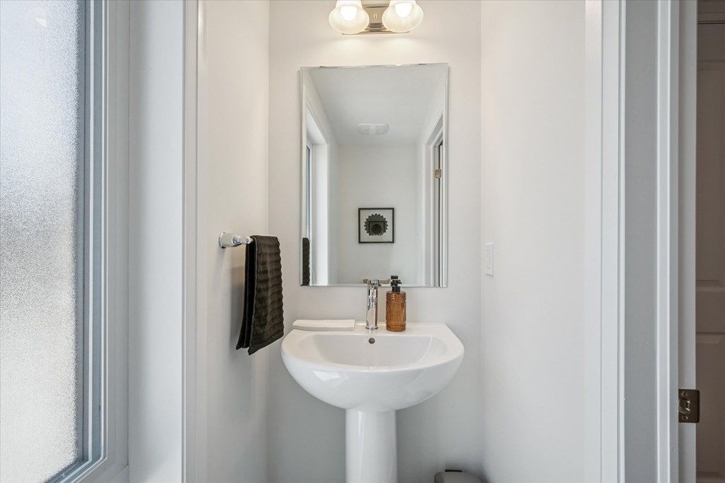 A white sink in a bathroom with a mirror above it.