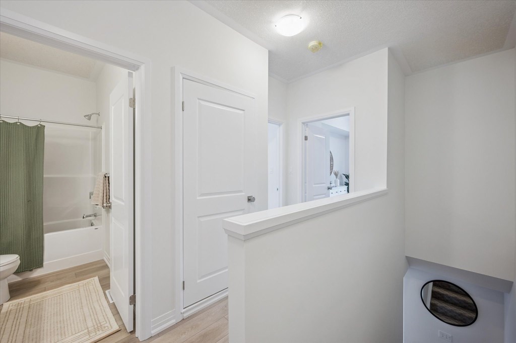 A white bathroom with a toilet, sink, and mirror.