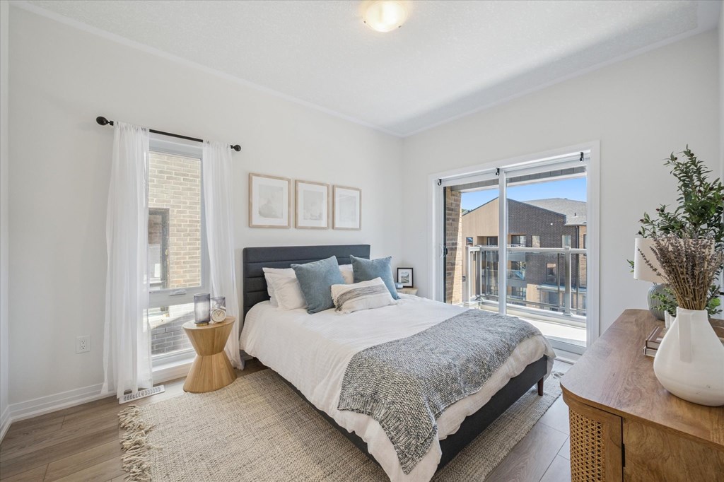 A bedroom with a large bed and a view of a balcony.