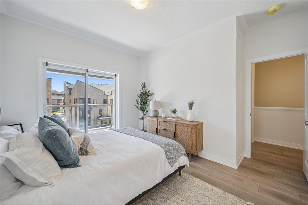A bedroom with a large bed and a window overlooking a cityscape.