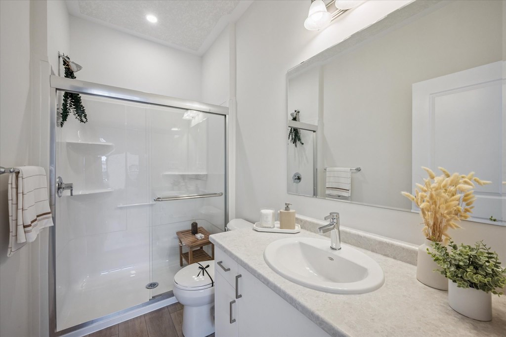 A bathroom with a toilet, sink, and shower.