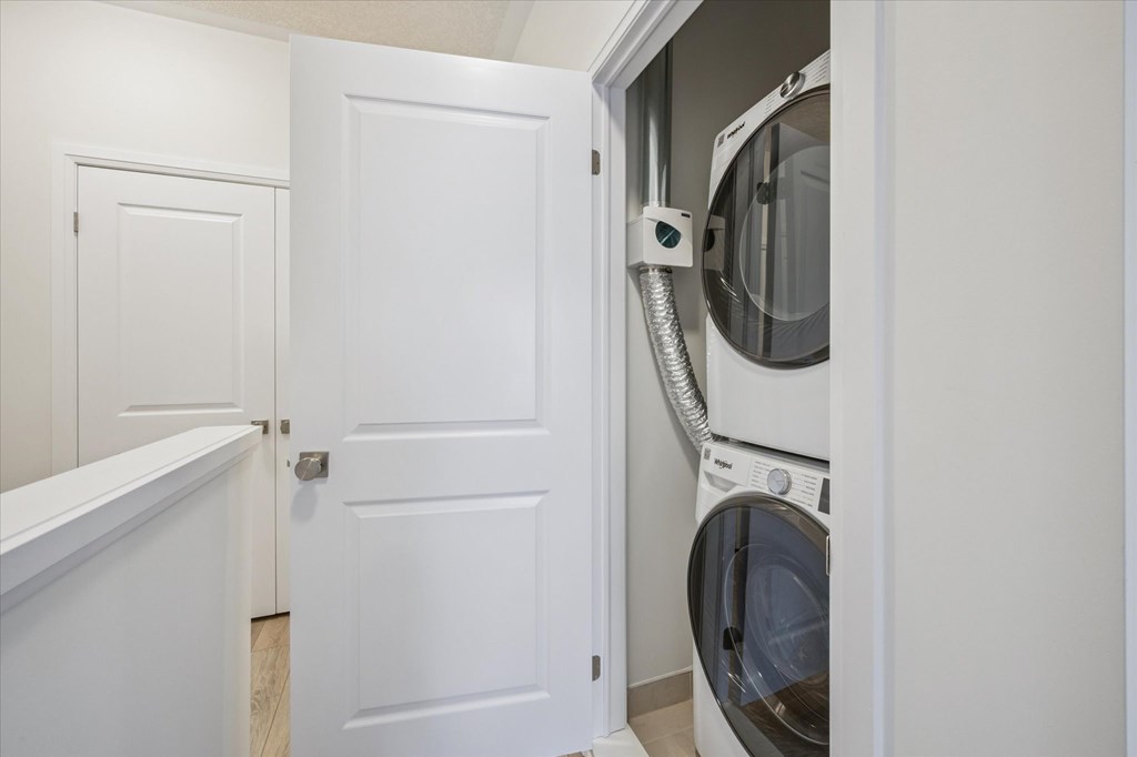 A white door is open to reveal a washing machine.